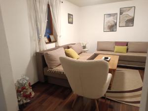 un soggiorno con un divano, un tavolo e delle sedie di Vlasic Relax Location a Vlasic