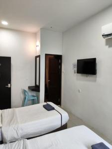a hotel room with two beds and a flat screen tv at comfortpahlawan in Sibu