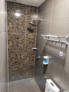 a bathroom with a shower with a glass door at comfortpahlawan in Sibu