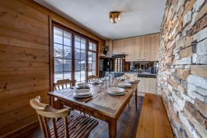 a dining room with a table and a stone wall at Chalet Fauvette in La Tzoumaz +17 photos