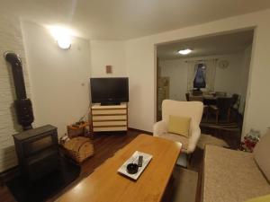 un soggiorno con un divano, una TV e un tavolo di Vlasic Relax Location a Vlasic