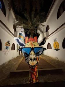 een schilderij van een giraffe met een zonnebril bij Shehab Dahab in Dahab