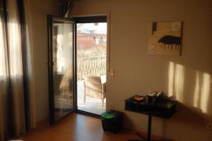 een kamer met een glazen deur naar een balkon bij Pension Zum Waldrand in Sinsheim