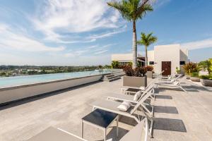 a row of lounge chairs on the roof of a building at Luxury Condo en Nuevo Vallarta Alberca Tipo Resort in Nuevo Vallarta