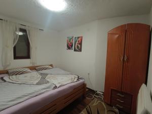 una camera da letto con un letto e un armadio in legno di Vlasic Relax Location a Vlasic