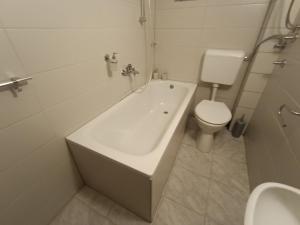 un bagno con una vasca bianca e un water di Vlasic Relax Location a Vlasic Altre 7 foto