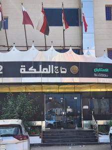 a store with flags on the front of a building at تاج الملكه للشقق المخدومة in Ḑirs +4 photos