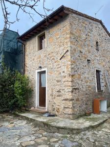 un edificio in pietra con una porta e una finestra di Rivolta home a Buti