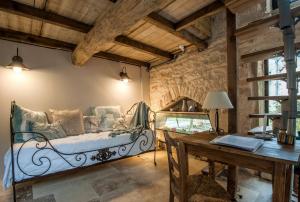 a bedroom with a bed and a table and a desk at Maison d'hôtes Moulin de Buffière in Montbellet