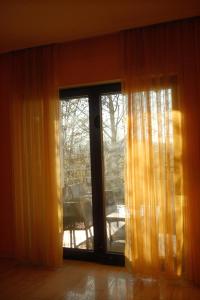 een kamer met een glazen schuifdeur en een raam bij Pension Zum Waldrand in Sinsheim +3 foto's