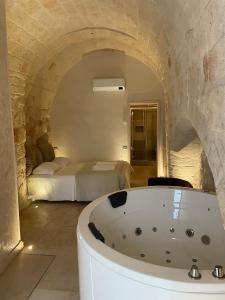 een bad in een kamer met een bed bij Barbacana46 Guest House in Monopoli