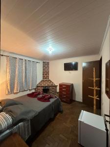 een slaapkamer met een bed en een stenen open haard bij Pousada Taquaral in Bocaina de Minas