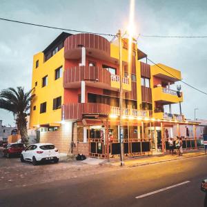 un edificio giallo e rosso con un'auto parcheggiata di fronte di Ferreira e Brito apartamentos a Espargos