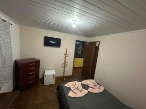 een slaapkamer met een bed, een dressoir en een tv bij Pousada Taquaral in Bocaina de Minas +1 foto
