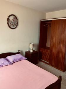 una camera da letto con un letto e un orologio sul muro di Ferreira e Brito apartamentos a Espargos