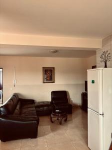 un soggiorno con divano in pelle nera e frigorifero bianco di Ferreira e Brito apartamentos a Espargos