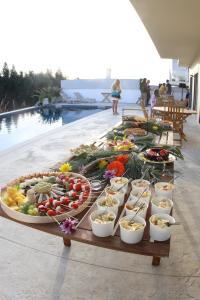 ein Buffet mit Speisen auf einem Tisch neben einem Pool in der Unterkunft Wellnesshouse in Atouguia da Baleia