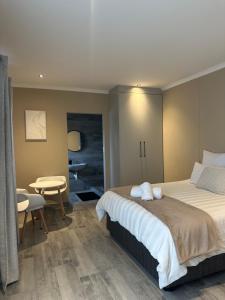 a bedroom with a large bed and a table at Guesthouse Le Michele in Swakopmund