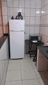 einen weißen Kühlschrank in einer Küche mit einem Tisch in der Unterkunft lar doce lar hospedaria 1 in Guarulhos + 3 Fotos