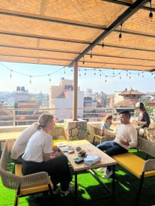 a group of people sitting at a table on a roof at Kasthamandap Boutique Hotel in Kathmandu