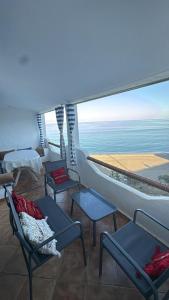 een kamer met stoelen en tafels en uitzicht op de oceaan bij Paradise Of Aouchtame in Aouchtame