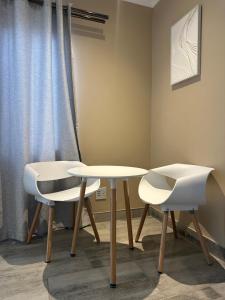 two tables and two chairs in a room at Guesthouse Le Michele in Swakopmund