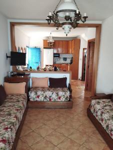 een woonkamer met twee bedden en een keuken bij Paradise Of Aouchtame in Aouchtame