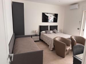 a bedroom with a bed and a table and chairs at Umberto Home 303 in Catania