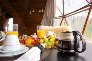 a table with a tea pot and a tray of fruit at Le Refuge Urubici in Urubici