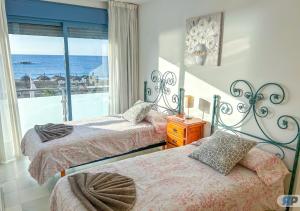 2 Betten in einem Schlafzimmer mit Meerblick in der Unterkunft Apartamentos Varadero sea view in La Cala del Moral + 84 Fotos