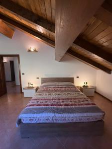 a bedroom with a large bed with wooden ceilings at Al Cacciatore in Gallio