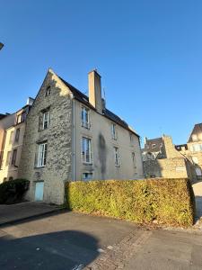een oud stenen gebouw met een heg ervoor bij Rive Gauche in La Celle-sous-Gouzon