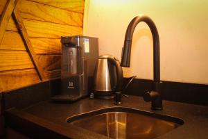 a kitchen counter with a sink and a coffee maker at Le Refuge Urubici in Urubici