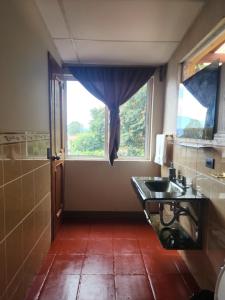 une salle de bain avec un lavabo et une fenêtre dans l'établissement Casa de Alondras, à Panajachel