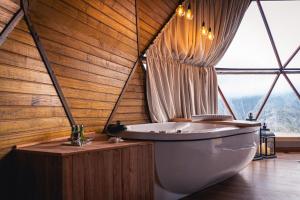 a bathroom with a tub and a large window at Le Refuge Urubici in Urubici +33 photos