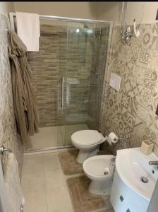 un bagno con doccia, WC e lavandino di La Casetta dei Fiori sull Etna a Ragalna