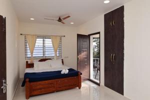 a bedroom with a bed with a ceiling fan at Marvel Homestay in Yercaud