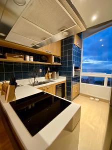 een keuken met een wastafel en een groot raam bij Ap Da Ilha in Alter do Chao