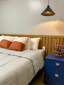 een slaapkamer met een bed, een blauw nachtkastje en een potplant bij Ap Da Ilha in Alter do Chao