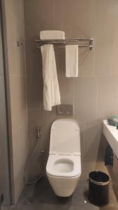 een badkamer met een wit toilet en handdoeken bij Denox house in Tanjungkarang