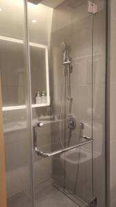 een douche in een badkamer met een glazen deur bij Denox house in Tanjungkarang