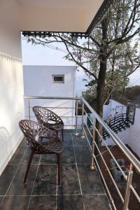 a balcony with a chair and a tree at Marvel Homestay in Yercaud