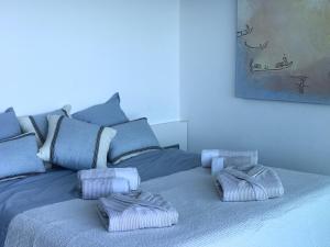 een blauw bed met drie kussens erop bij C'est la vie! in L'Escala