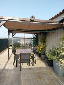 a table and chairs under a pergola on a patio at Le Golfe in Figari