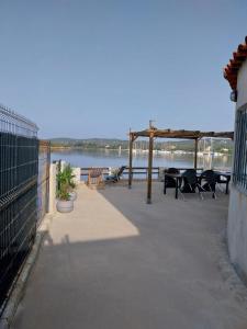 a patio with tables and chairs next to the water at Le Golfe in Figari