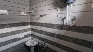 een badkamer met een toilet en een douche bij Oak sunlight Restaurant & Provides Famous Gadwali food in Mussoorie