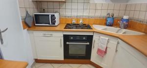 a small kitchen with a microwave and a sink at Entre sel et vignes in Lons-le-Saunier