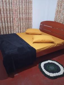 a bed in a room with yellow sheets and pillows at Mountain View in Bandarawela