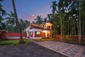 ein Haus mit Palmen davor in der Unterkunft ll EMPYREAN STAY ll REVDANDA BEACH ll in Revadanda