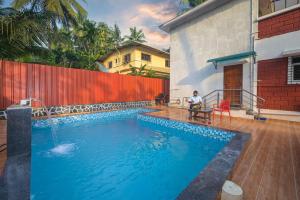 ein Mann sitzt auf einem Tisch neben einem Swimmingpool in der Unterkunft ll EMPYREAN STAY ll REVDANDA BEACH ll in Revadanda + 19 Fotos